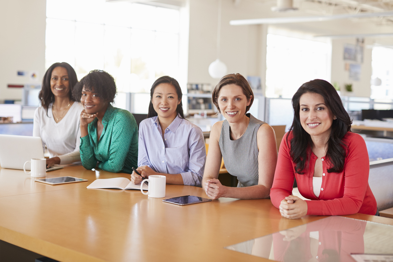 Female business colleagues in an office smiling to camera